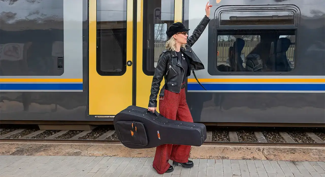 chitarrista trasporta la sua chitarra con una custodia semirigida tobago durante il suo viaggio in treno